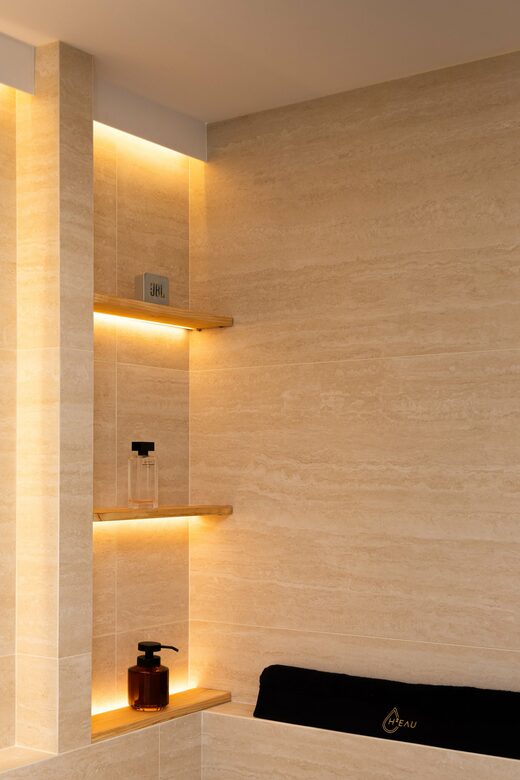Salle de bain en travertin et éclairage indirect à Cabestany