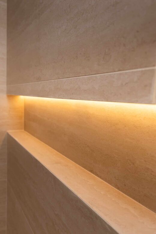 Salle de bain en travertin et éclairage indirect à Cabestany
