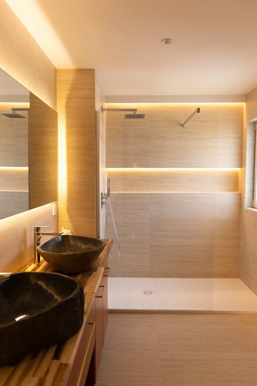 Salle de bain en travertin et éclairage indirect à Cabestany