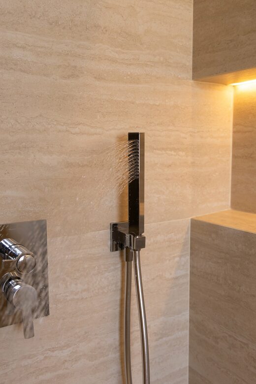 Salle de bain en travertin et éclairage indirect à Cabestany
