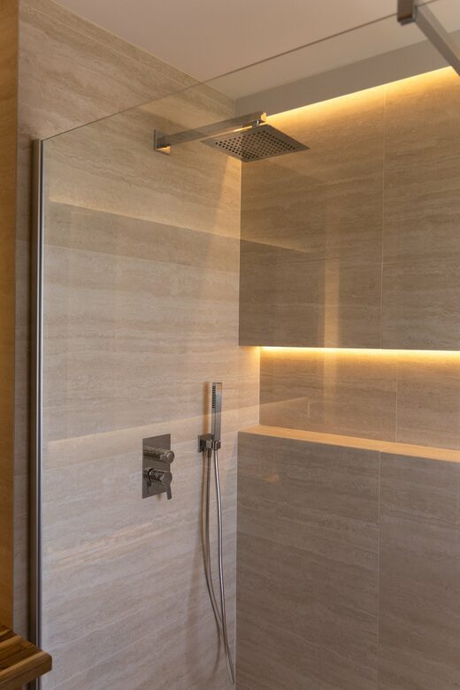 Salle de bain en travertin et éclairage indirect à Cabestany
