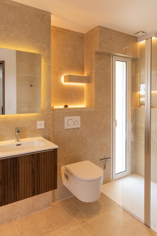 Salle de bain en travertin et éclairage indirect à Cabestany