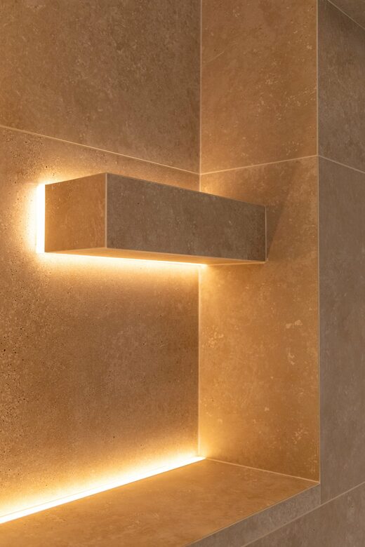 Salle de bain en travertin et éclairage indirect à Cabestany