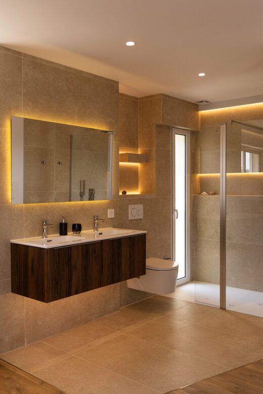 Salle de bain en travertin et éclairage indirect à Cabestany